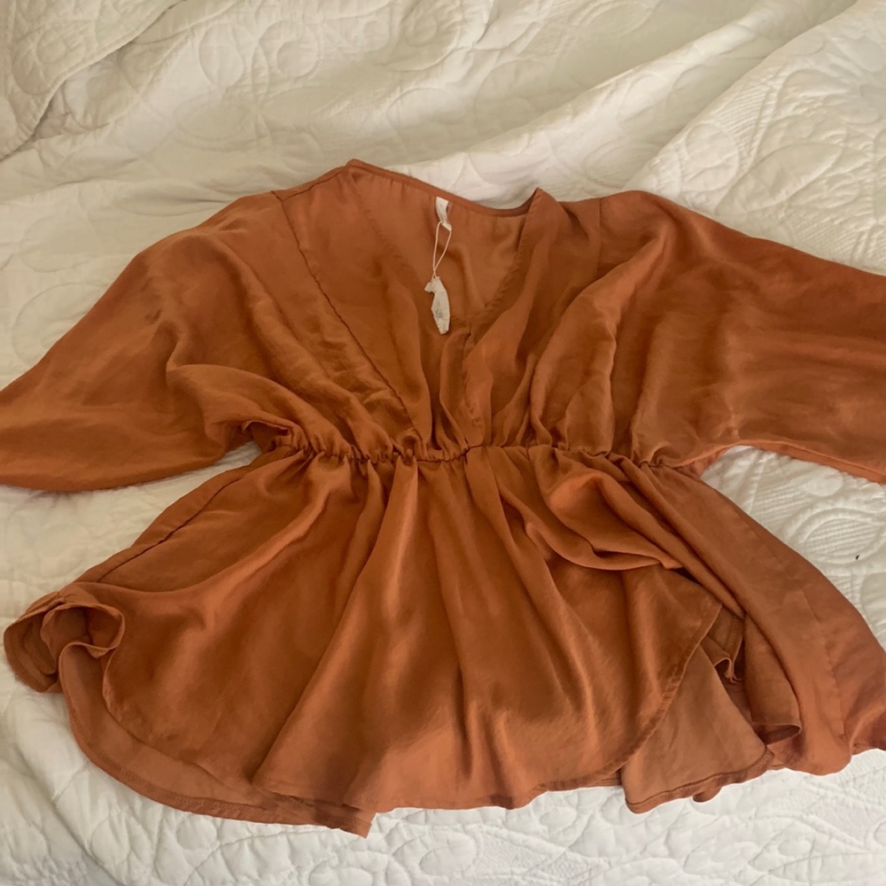 Never worn- beautiful burnt orange top. Runs large — so could fit L, XL, XXL